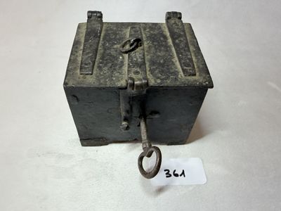 une petite boîte en métal à laquelle est attachée une clé