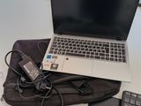 un ordinateur portable posé sur un sac, à côté d'un clavier