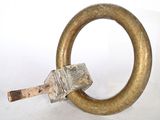 a metal ring with a wooden handle on a white surface