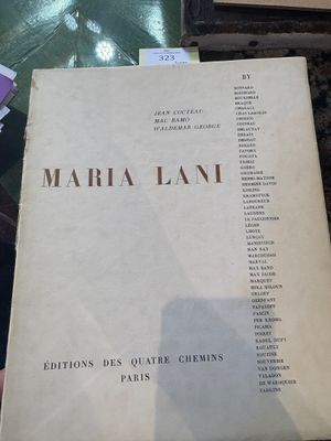 un livre posé sur une table, à côté d'une pile de livres