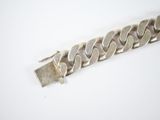 a close up of a silver bracelet on a white surface