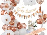 une décoration de fête prénatale dans les tons blanc et or, avec des ballons et un gâteau