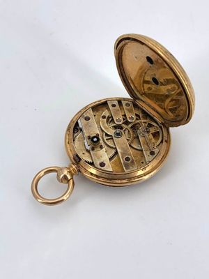 an image of a gold pocket watch on a white surface
