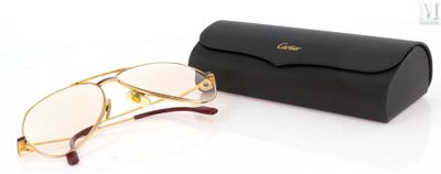 des lunettes de soleil dans un étui noir et une paire de lunettes posée sur une surface blanche
