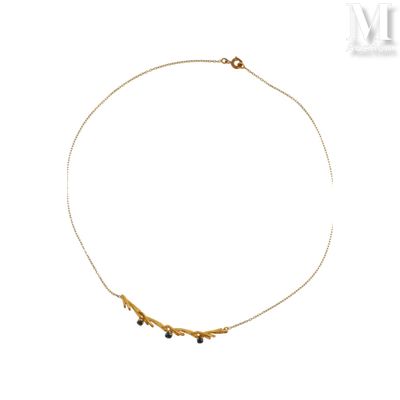un gros plan d'un collier en or orné de perles noires sur fond blanc