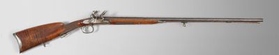 un vieux fusil avec un canon en bois et une poignée en métal