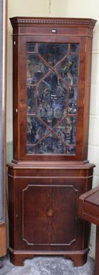 une armoire en bois avec une porte vitrée, dans un coin de la pièce