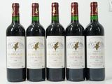 quatre bouteilles de vin sont alignées sur une surface blanche