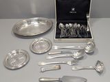 a box of silverware on a table with a knife, fork, spoon, and spoon rest