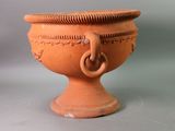 a large orange vase with a handle on it