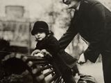 une photo en noir et blanc d'un homme et d'un enfant assis sur un banc dans un parc