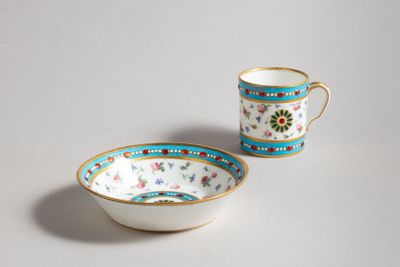 two cups and a saucer sitting on a white surface