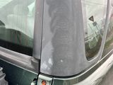 un homme assis à l'arrière d'une voiture, un téléphone portable à la main