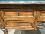 a wooden desk with two drawers and a glass top