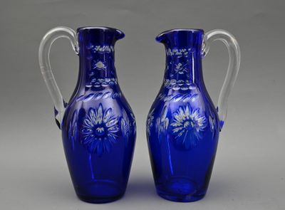 une paire de vases en verre bleu ornés de fleurs sur fond gris