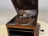 un vieux tourne-disque posé sur une table, à côté d'une télécommande