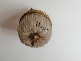 a gold purse hanging from the ceiling on a white wall