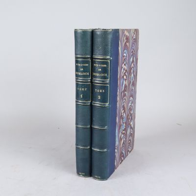 deux livres bleus posés l'un sur l'autre sur une surface blanche