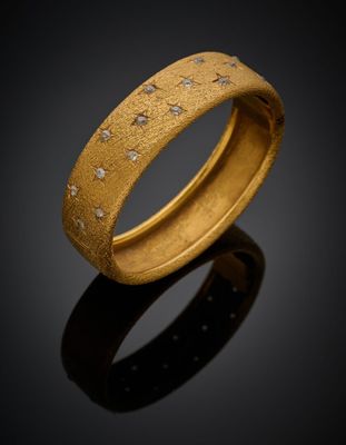 gros plan d'une bague en or avec des diamants sur une surface noire