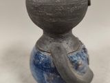 a small vase with a handle on it on a table
