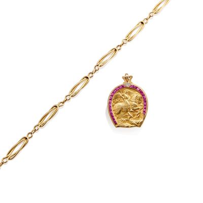 a close up of a gold chain bracelet with a gold coin on it