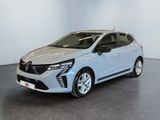 Une voiture argentée est garée dans une pièce aux murs blancs.