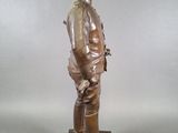 statue of a man in a military uniform standing on a wooden base
