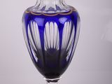 vase en verre bleu avec un bord et un socle dorés, sur fond blanc