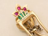 a gold brooch with a bouquet of flowers on it