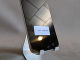 un téléphone portable posé sur un support, sur lequel figure un message