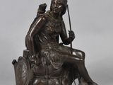 an image of a bronze statue of a woman sitting on a chair