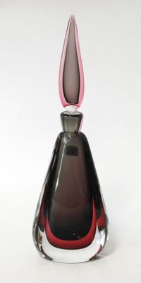a glass vase with a pink top on a white surface