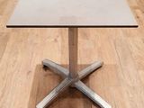 une table blanche avec un piètement argenté posée sur un parquet
