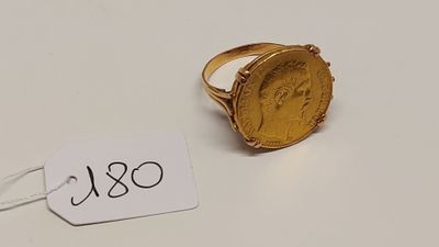 Gros plan sur une bague ornée d'une pièce d'or