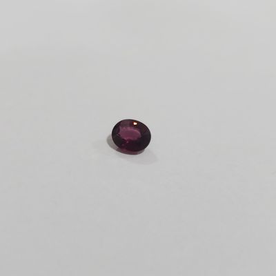 a close up of a purple gemstone on a white surface