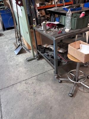 une photo d'un espace de travail avec une table et des tabourets