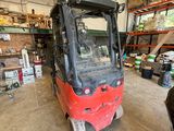 a red fork truck parked inside of a warehouse