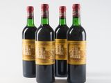 four bottles of wine are lined up on a white surface