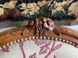 a close up of a wooden chair with a floral pattern on it