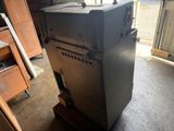 an old stove sitting in a room with a lot of wood