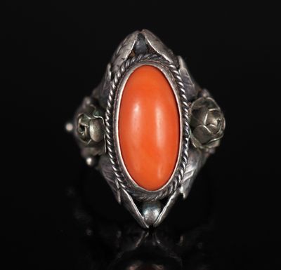 un gros plan d'une bague en argent sertie d'une pierre orange