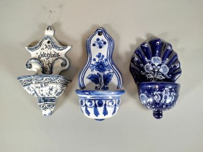 trois vases bleus et blancs accrochés au mur