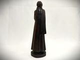 statue of a woman in a black robe standing on a black base