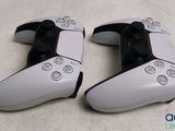 two video game controllers sitting side by side on a table