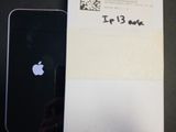 un iPhone noir posé à côté d'une feuille de papier sur laquelle figure un code QR