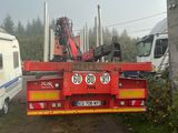un camion rouge équipé d'une grue à l'arrière