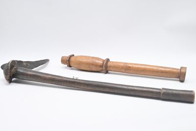 Deux vieux outils sont posés sur une surface blanche