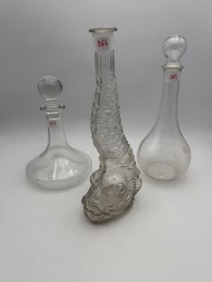 trois vases en verre posés l'un à côté de l'autre sur une table