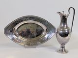 un plateau en argent et un pichet en argent posés sur une table