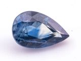 a close up of a blue sapphire stone on a white surface